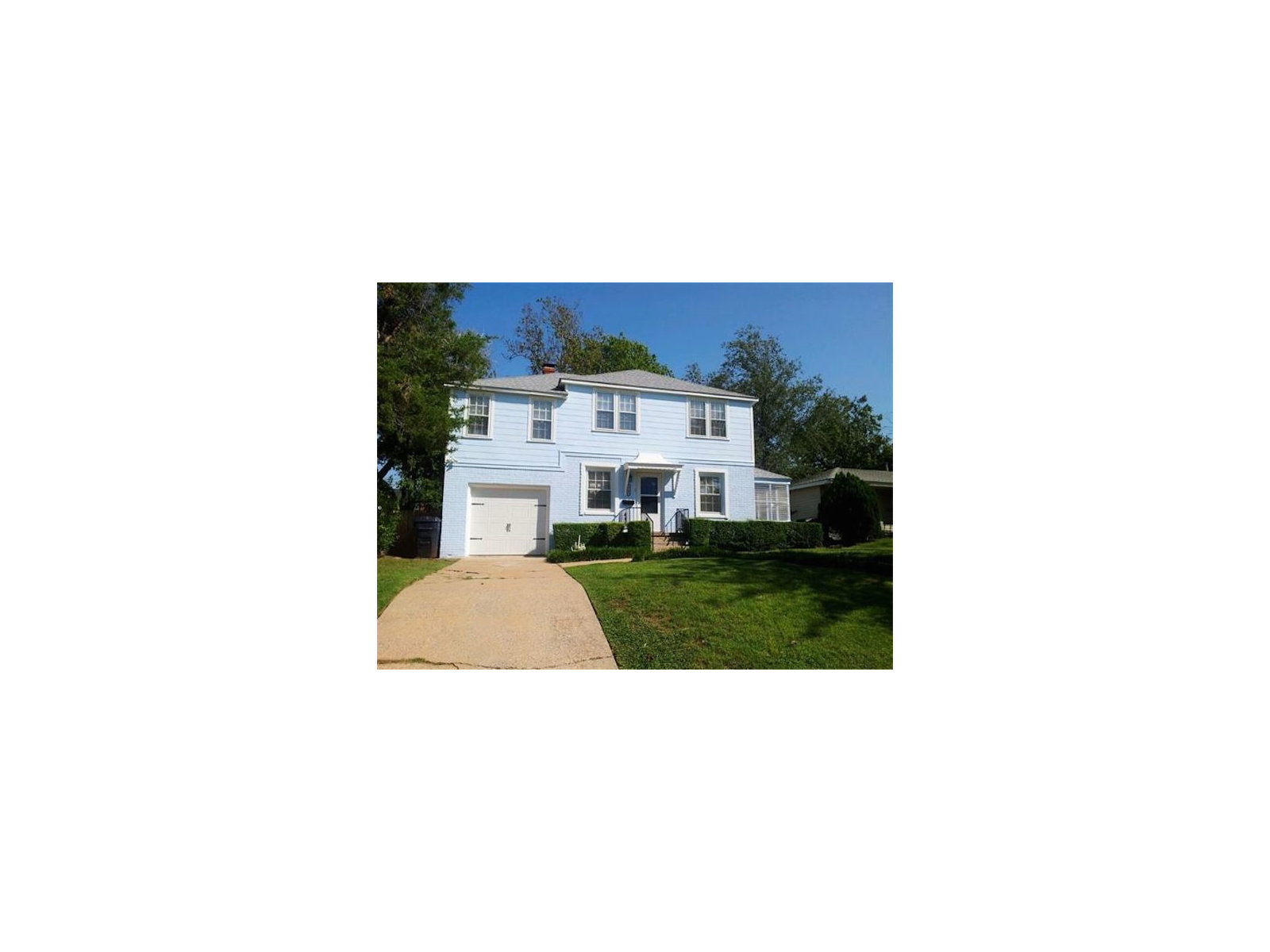 Bright blue two-story Oklahoma City home with fresh-looking painted siding, white trim and a neatly kept hedge.